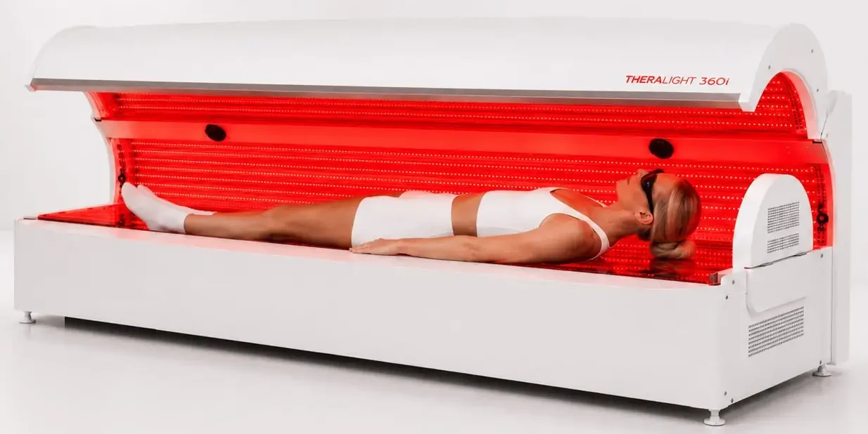 The TheraLight 360i full-body red light therapy bed, lit red