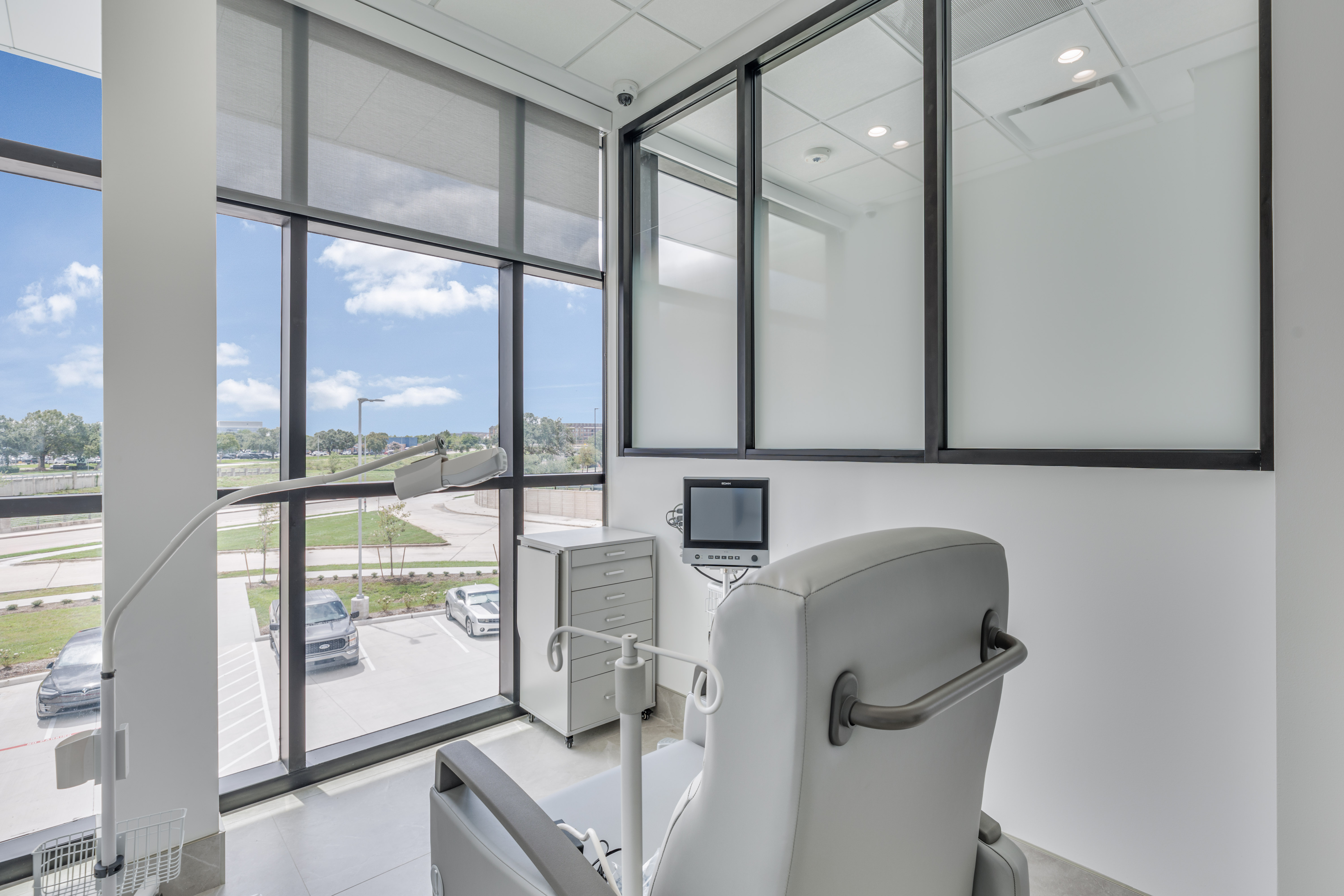 Private infusion room with a reclining treatment chair and patient monitor
