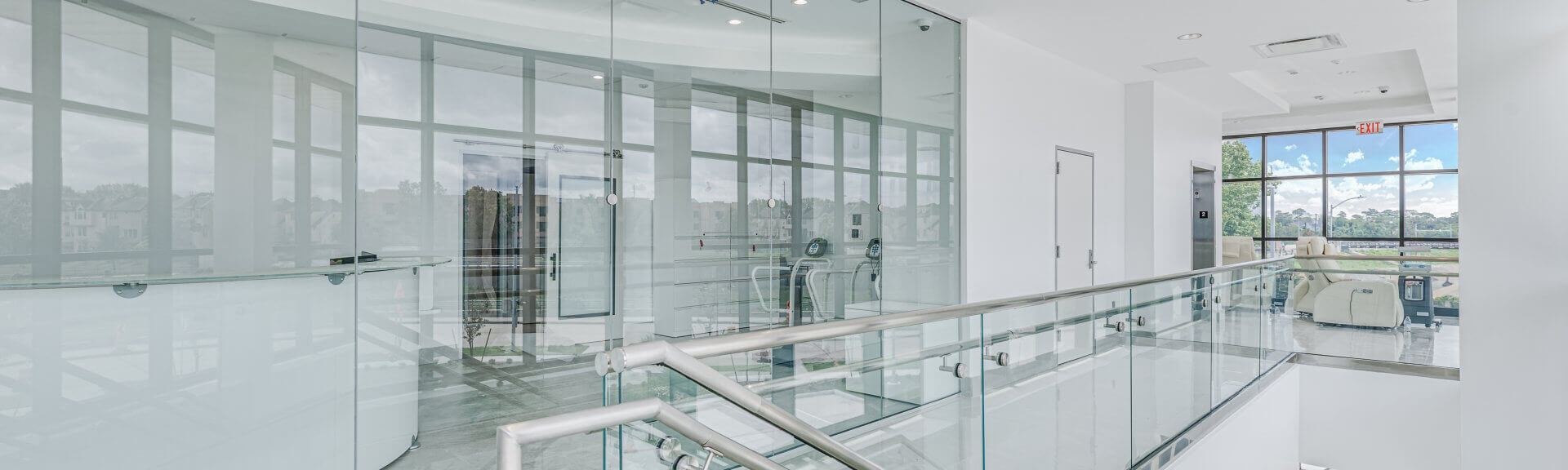 Upstairs infusion center with glass railings and floor-to-ceiling windows